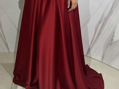 Deep red satin skirt falling in soft folds, held out to show the drape